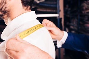 fashion-designer-taking-measurement-his-customer-s-back-with-yellow-measuring-tape_23-2148180303