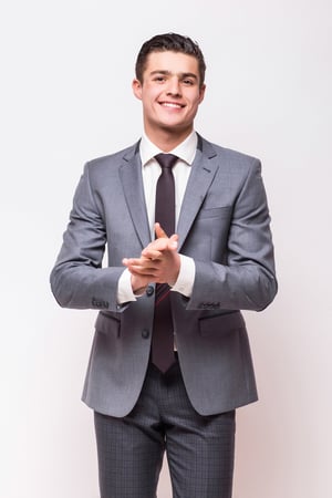 happy-business-man-wearing-grey-suit-standing-isolated-white-wall